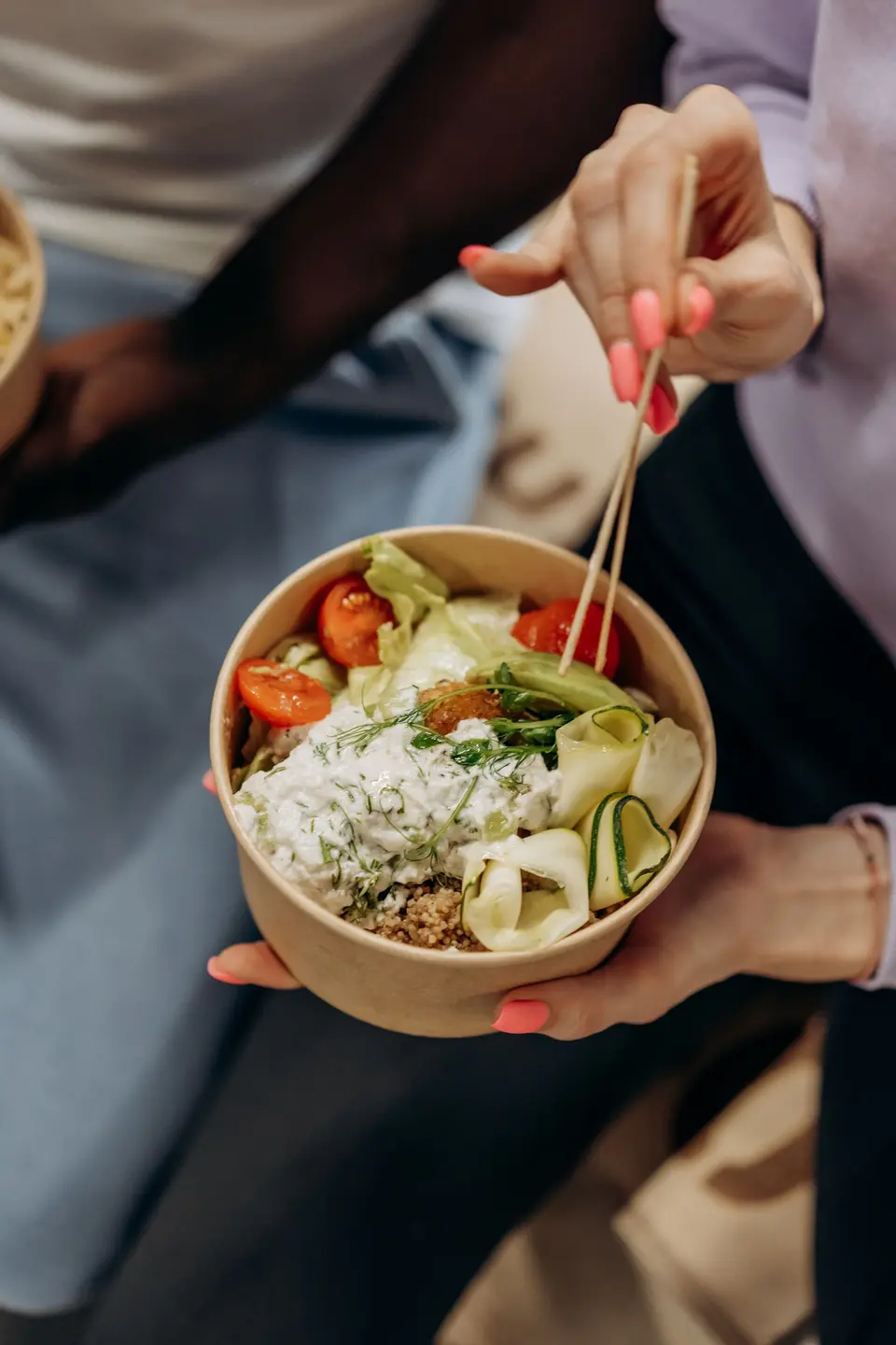 A salad bowl in a kraft paper bowl, eaten with wooden chopsticks