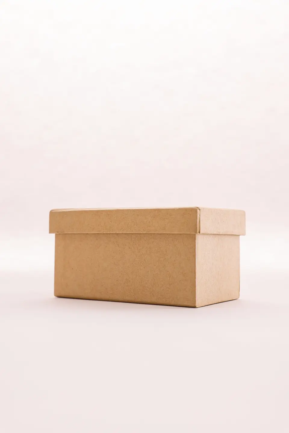 Plain kraft box with a lift-off lid on a pale background