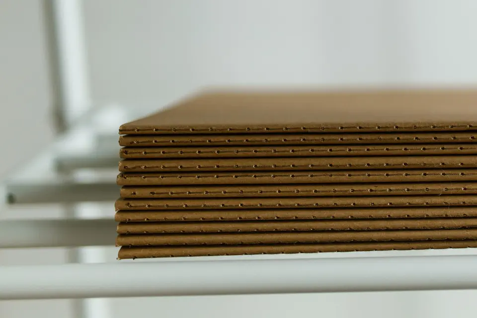 Stack of flat corrugated board sheets on a shelf