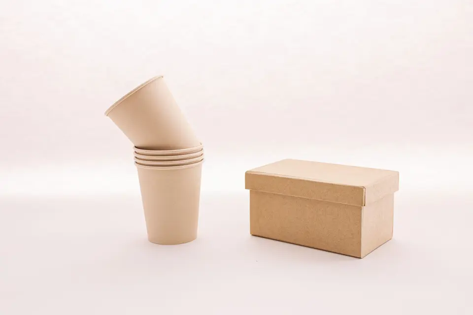 Kraft paper cups stacked next to a lidded kraft box